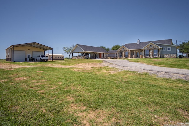 view of yard with an outbuilding, a carport, and a garage