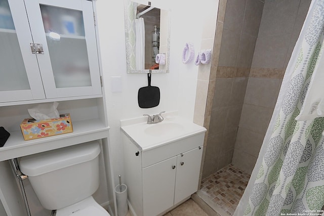 bathroom featuring tile patterned floors, vanity, toilet, and curtained shower