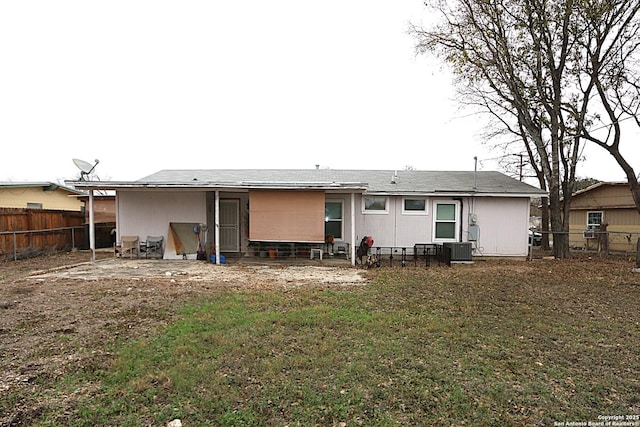 rear view of house with a lawn and central AC