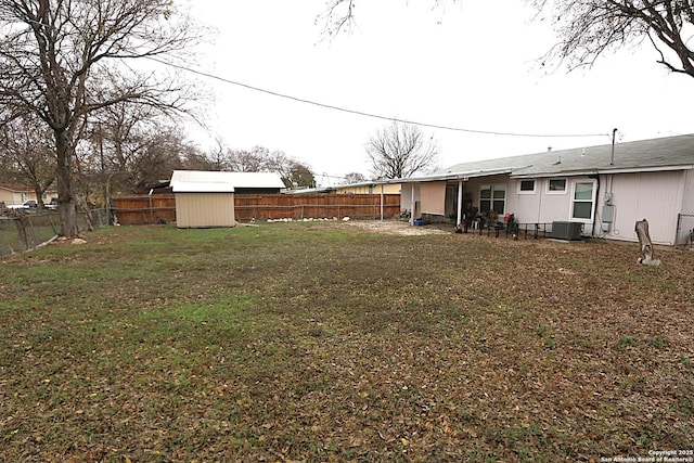 view of yard featuring central AC and a shed