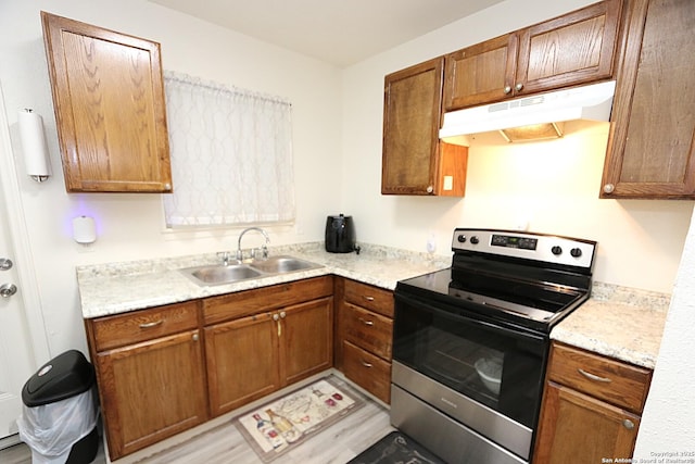 kitchen featuring electric range, sink, and light hardwood / wood-style flooring