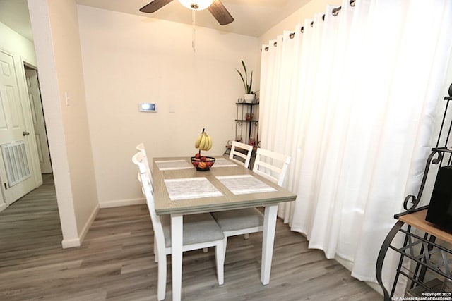 dining space featuring wood-type flooring and ceiling fan