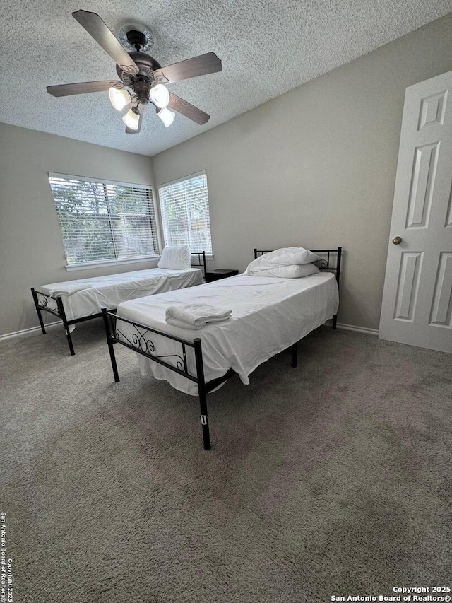 bedroom with ceiling fan, a textured ceiling, and carpet flooring