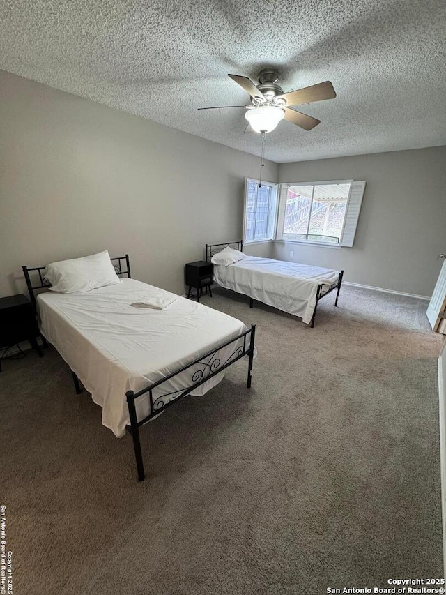 carpeted bedroom featuring ceiling fan and a textured ceiling