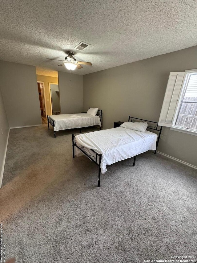 bedroom with a textured ceiling, ceiling fan, and carpet