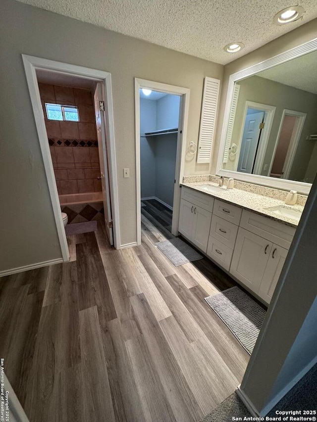 bathroom featuring vanity, wood-type flooring, and a textured ceiling