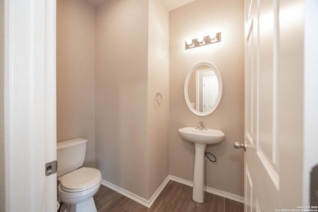 bathroom featuring wood-type flooring and toilet