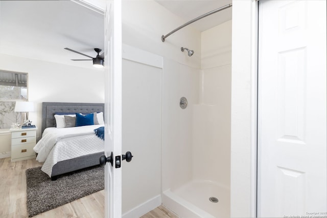 bathroom with walk in shower, hardwood / wood-style floors, and ceiling fan