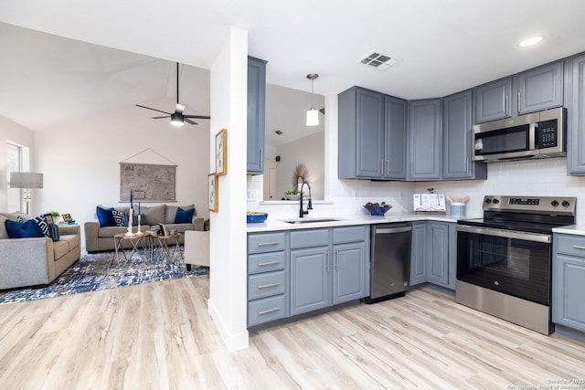 kitchen featuring tasteful backsplash, sink, lofted ceiling, and appliances with stainless steel finishes