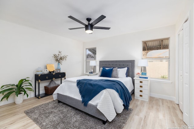 bedroom with ceiling fan, light hardwood / wood-style floors, and a closet