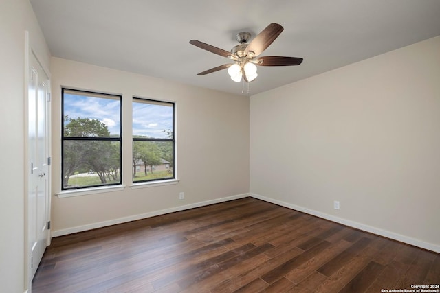 empty room with ceiling fan and dark wood-type flooring