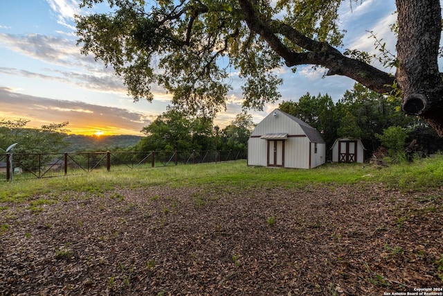 yard at dusk featuring a shed