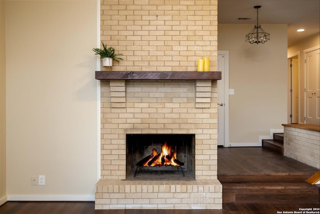 interior details featuring hardwood / wood-style flooring and a brick fireplace