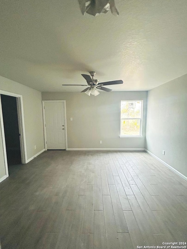 empty room featuring ceiling fan, hardwood / wood-style floors, and a textured ceiling