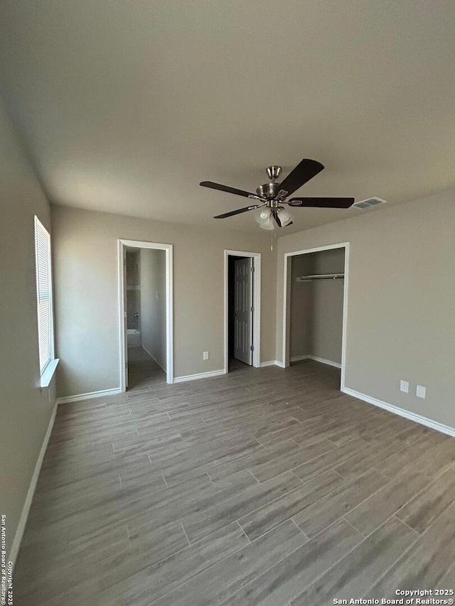 unfurnished bedroom featuring light wood-type flooring, connected bathroom, and ceiling fan