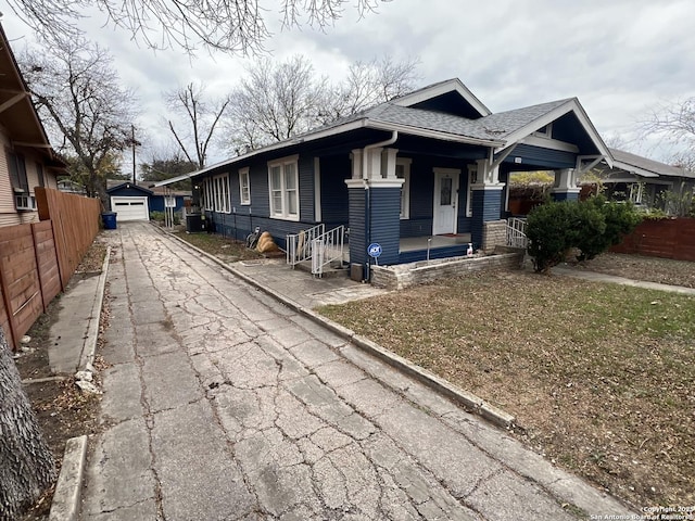 view of front of home featuring a garage and an outbuilding