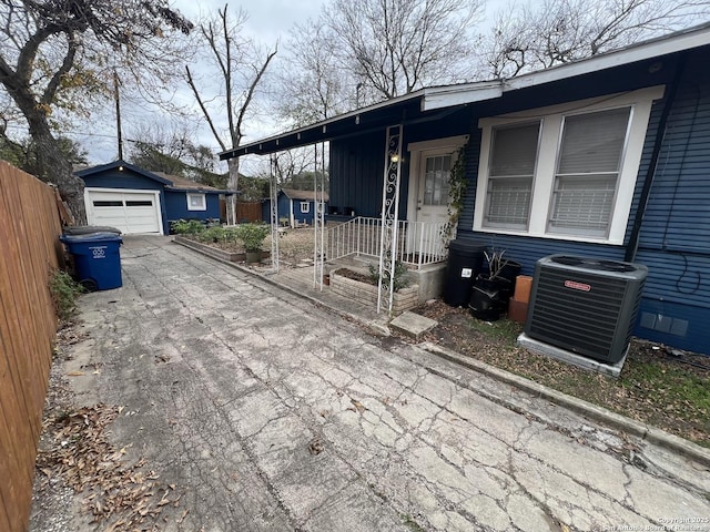 view of front of house featuring a garage, central AC unit, and an outdoor structure