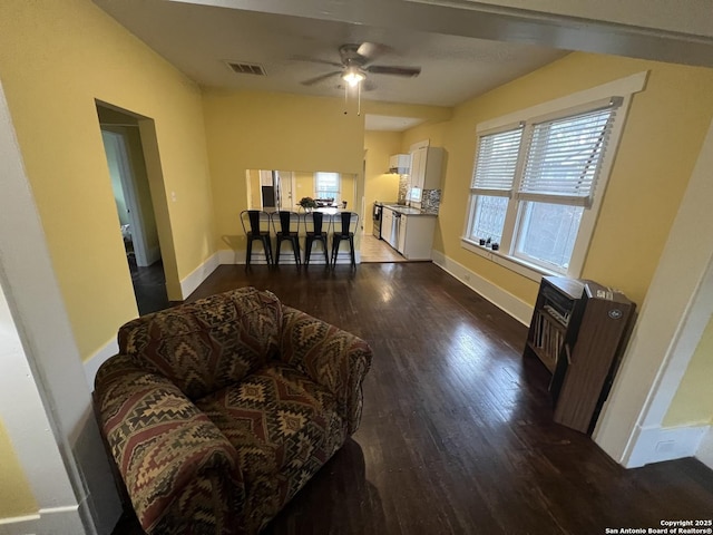 living room with ceiling fan and dark wood-type flooring