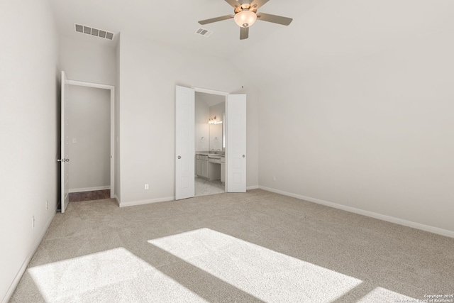 unfurnished bedroom featuring connected bathroom, light colored carpet, and ceiling fan