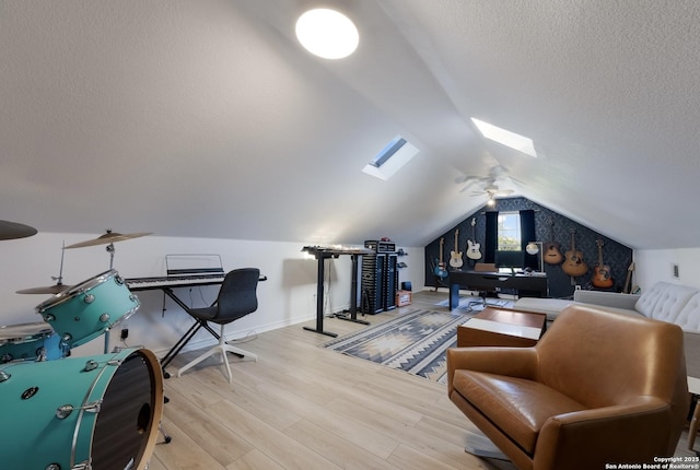 office space with ceiling fan, wood-type flooring, a textured ceiling, and lofted ceiling with skylight