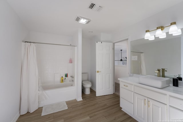 full bathroom featuring hardwood / wood-style floors, vanity, toilet, and shower / bathtub combination with curtain