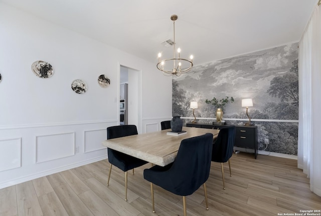 dining area featuring light hardwood / wood-style flooring and a notable chandelier