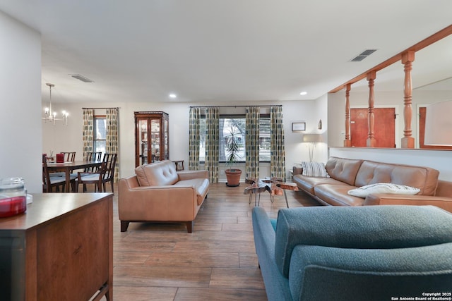 living room featuring hardwood / wood-style flooring, a wealth of natural light, and an inviting chandelier