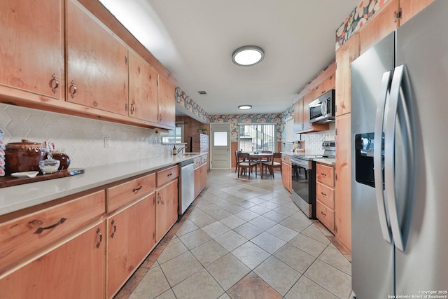 kitchen with decorative backsplash, light tile patterned floors, and appliances with stainless steel finishes