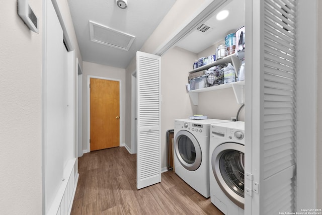 laundry room featuring light hardwood / wood-style floors and independent washer and dryer