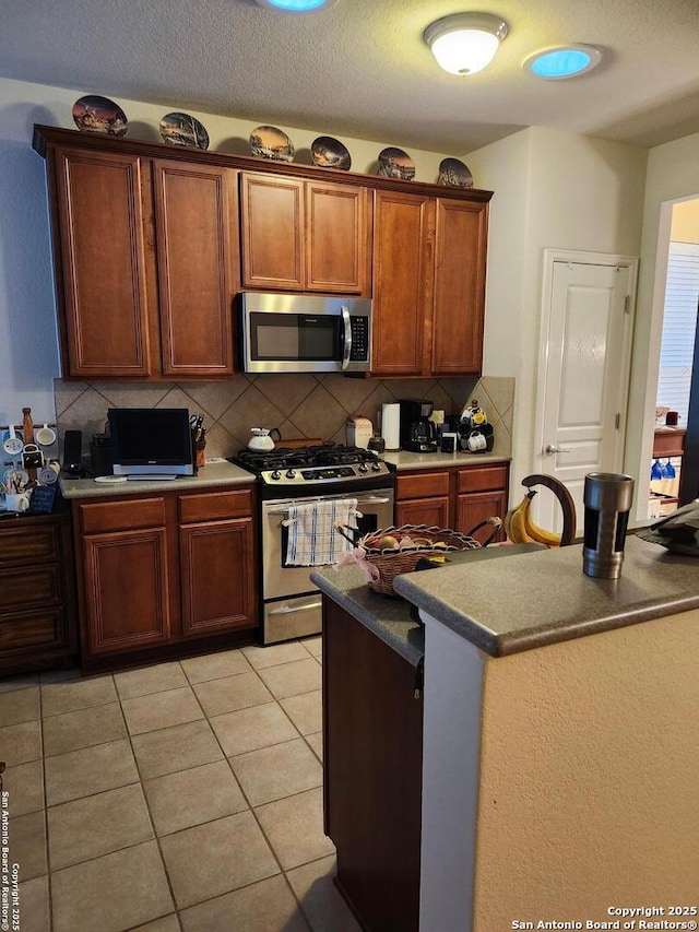 kitchen with light tile patterned floors, stainless steel appliances, and tasteful backsplash