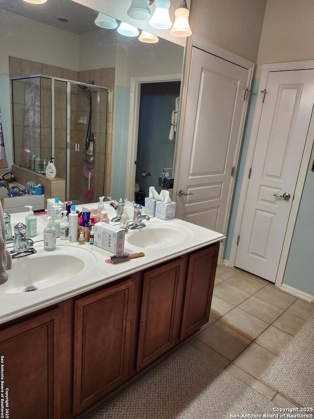 bathroom with tile patterned floors, vanity, toilet, and an enclosed shower