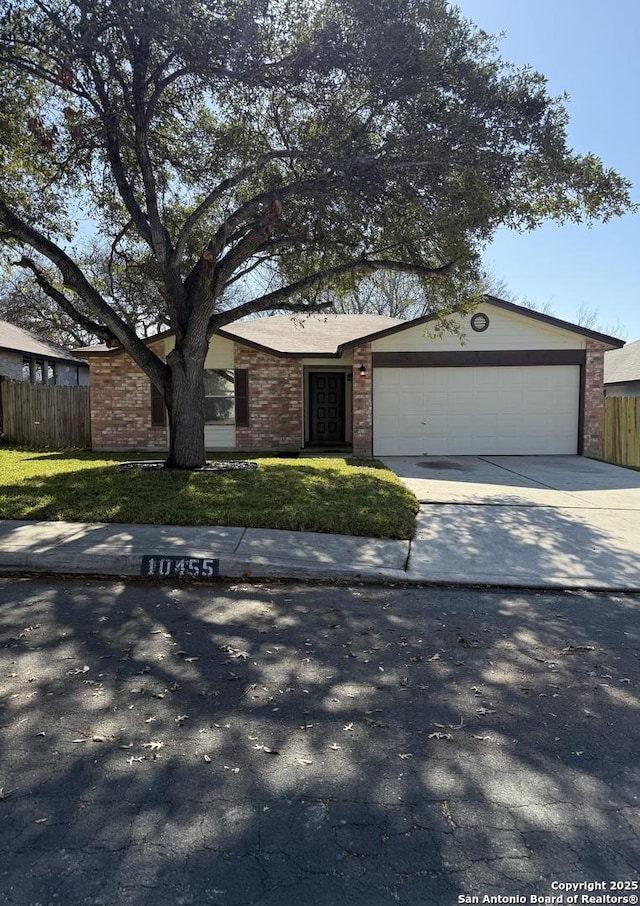 ranch-style home featuring a garage and a front lawn