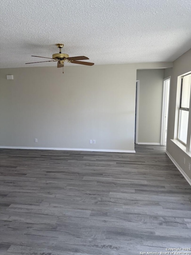 spare room with a textured ceiling and dark hardwood / wood-style floors