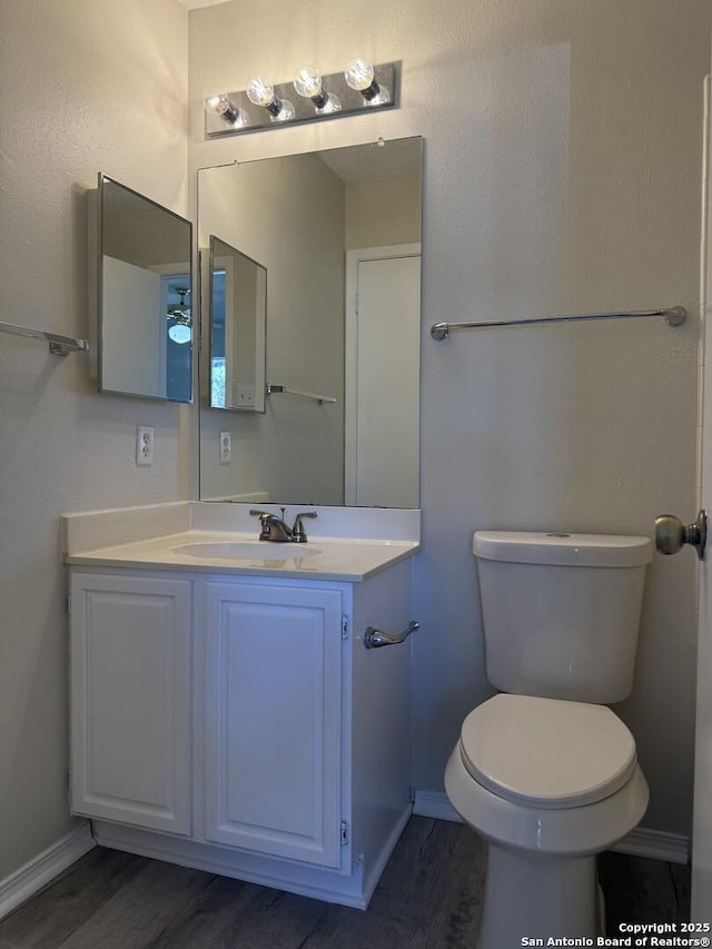 bathroom with hardwood / wood-style floors, vanity, and toilet