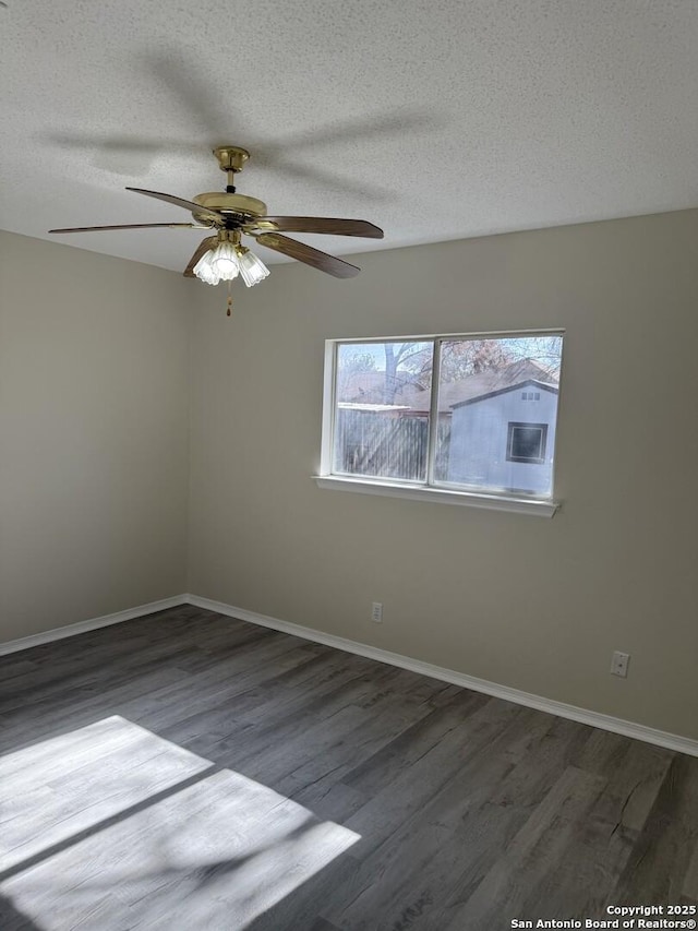 empty room with ceiling fan, dark wood-type flooring, and a textured ceiling