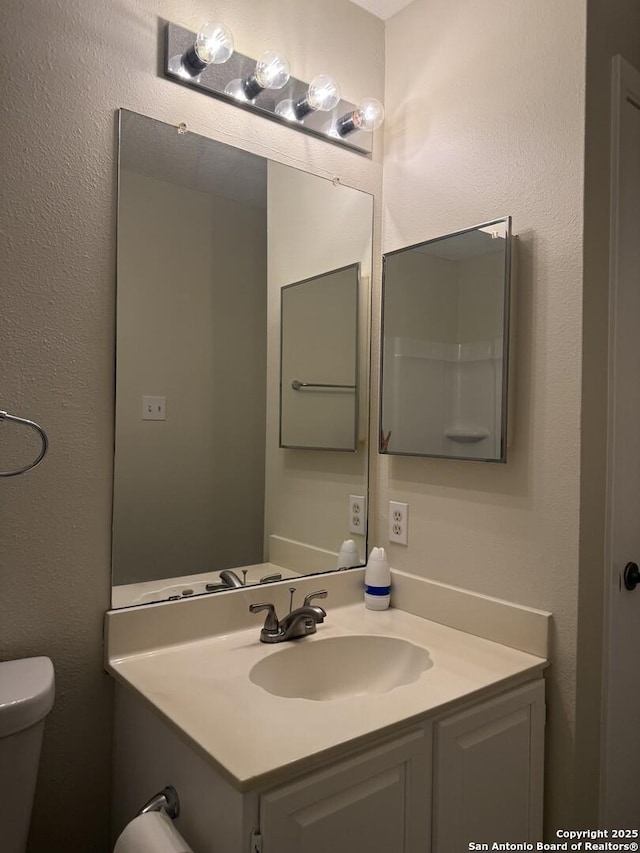 bathroom featuring vanity and toilet