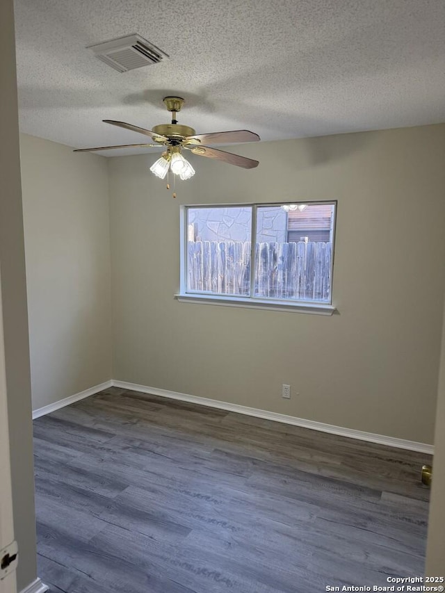 unfurnished room featuring ceiling fan, dark wood-type flooring, and a textured ceiling