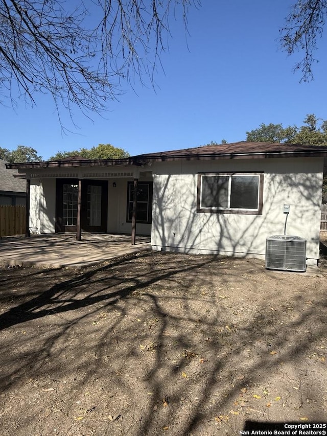 rear view of property with central AC unit and a patio