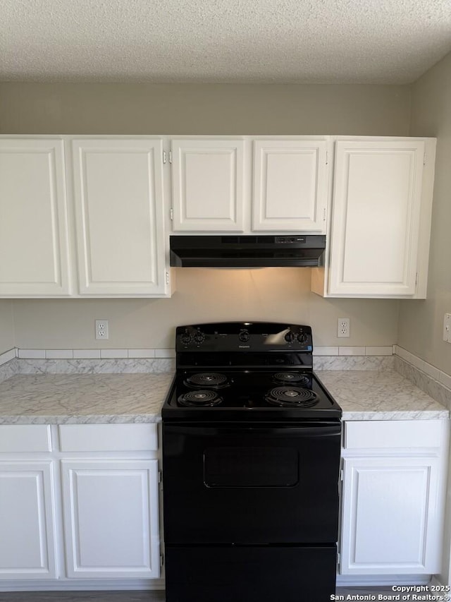 kitchen featuring black electric range, white cabinets, and a textured ceiling