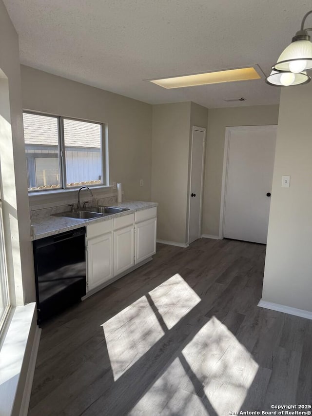 kitchen with light stone counters, dark wood-type flooring, sink, black dishwasher, and white cabinetry