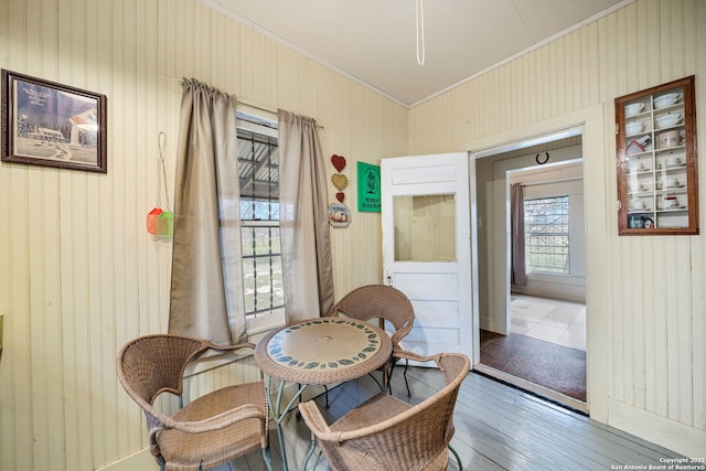 interior space with crown molding, wooden walls, and hardwood / wood-style flooring