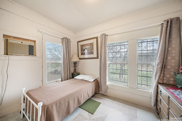 bedroom with wood walls and a wall unit AC