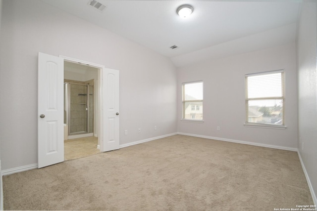 carpeted spare room featuring lofted ceiling