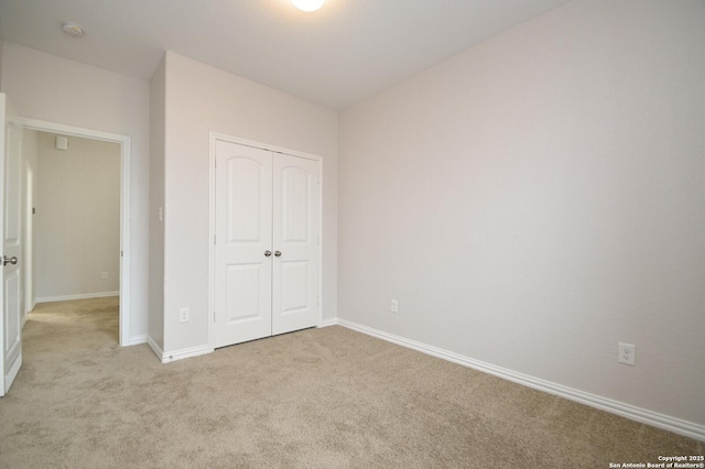 unfurnished bedroom featuring a closet and light colored carpet