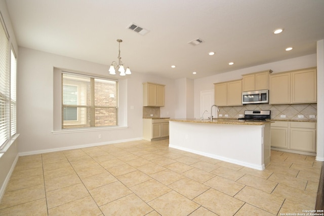 kitchen featuring a kitchen island with sink, an inviting chandelier, light tile patterned floors, and range