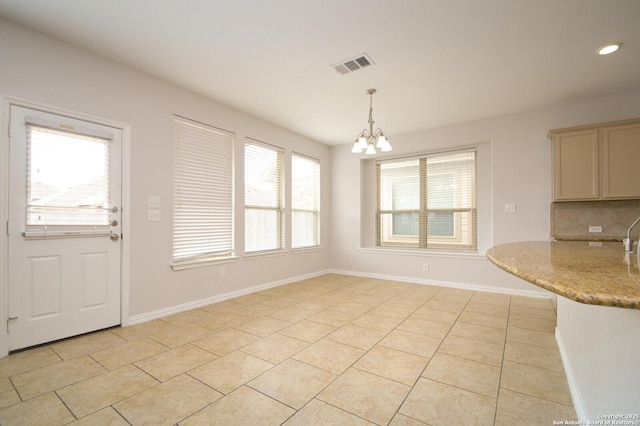 unfurnished dining area with a chandelier and light tile patterned floors