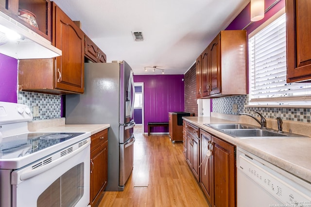 kitchen featuring sink, tasteful backsplash, ventilation hood, white appliances, and light wood-type flooring