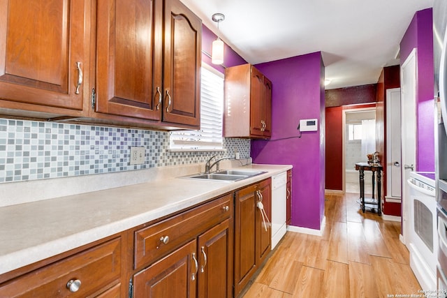 kitchen featuring white dishwasher, pendant lighting, a healthy amount of sunlight, and sink