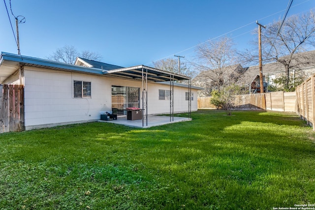 back of property with a lawn and a patio area