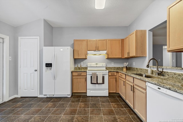 kitchen with light stone counters, white appliances, sink, and light brown cabinetry